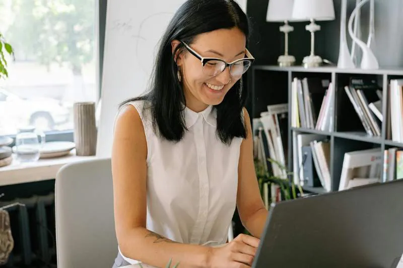 Woman using her laptop to learn how to fill out a W-4 form for tax withholding.
